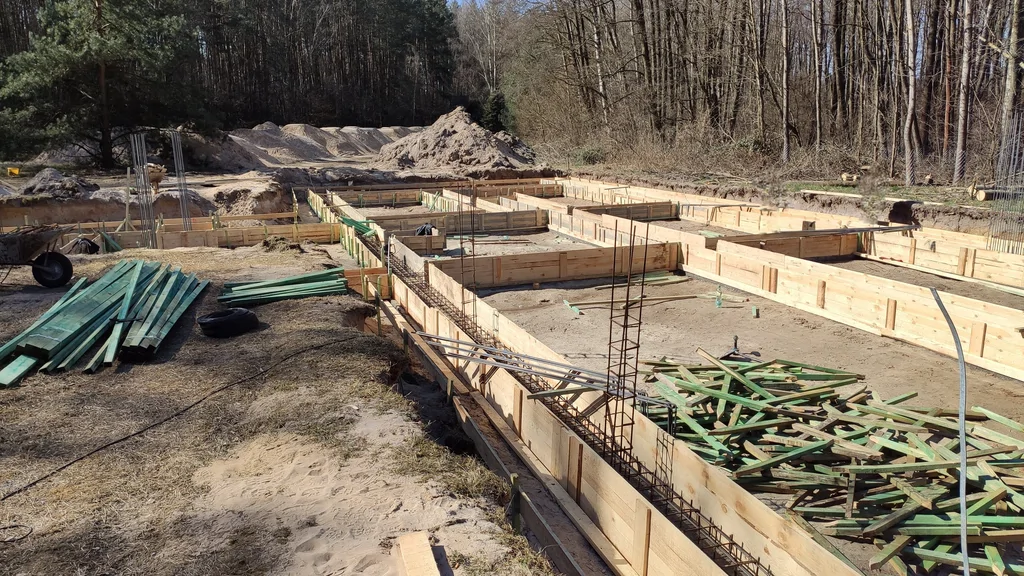 Układ ław fundamentowych w deskowaniu z przygotowanym zbrojeniem pod ławy fundamentowe