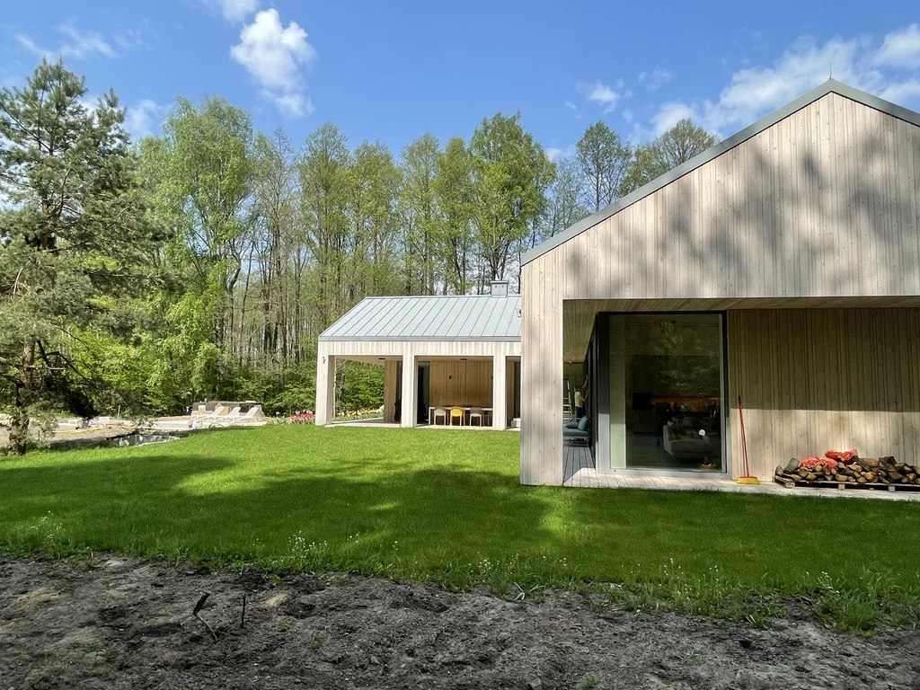 Elewacja domu z drewnianym wykończeniem i dużymi oknami