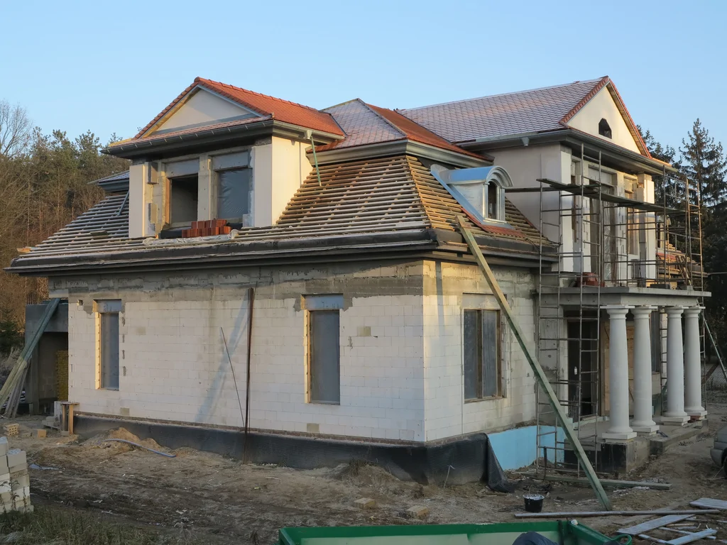 Wykonany budynek w stanie surowym, Więźba dachowa częściowo pokryta karpiówką, lukarna dachowa 