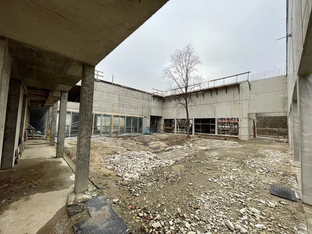 Wnętrze dziedzińca: konstrukcja parteru z betonu architektonicznego i stropy żelbetowe – etap stanu surowego