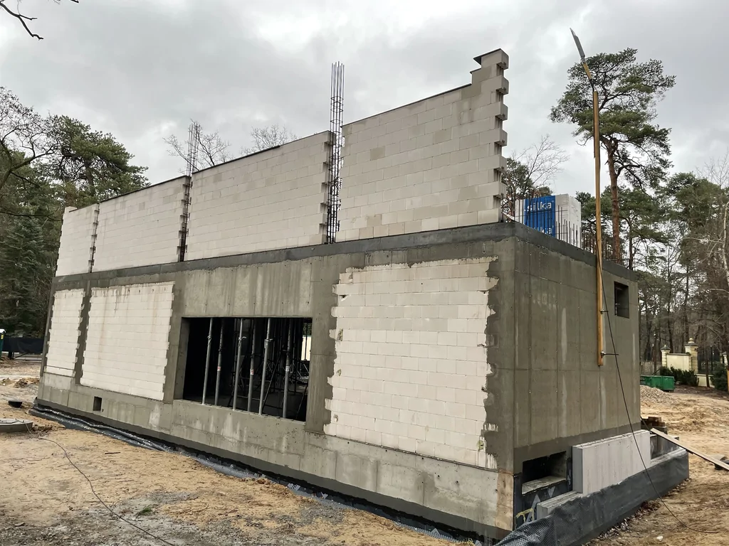 Widok boczny domu jednorodzinnego z żelbetową piwnicą i murowanymi ścianami parteru