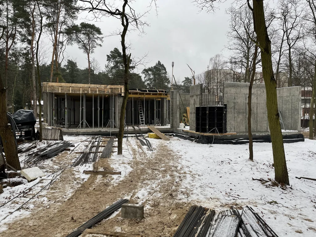 Stan surowy konstrukcji żelbetowej domu zimą z deskowaniem stropu i ścianami podziemia