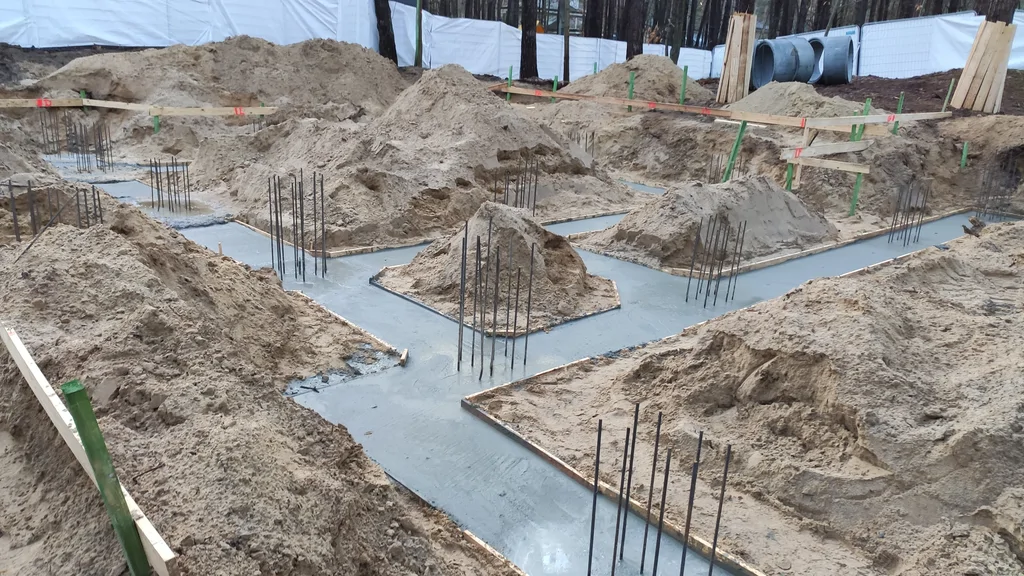 Wykonane ławy i stopy fundamentowe ze zbrojeniem pod budowę domu na studniach w Magdalence