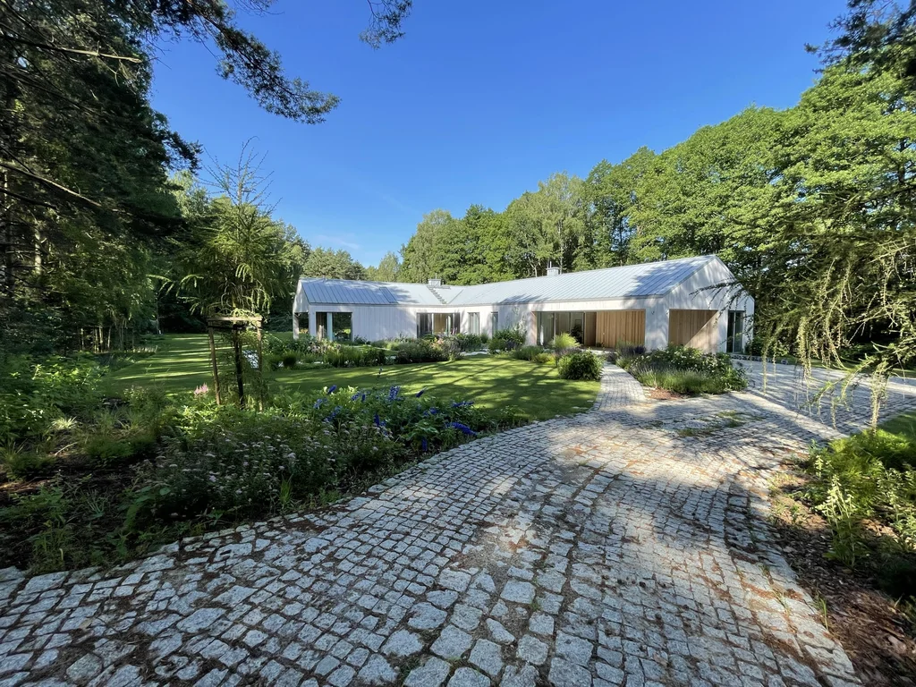 Widok ogólny z dojazdu – kompozycja bryły parterowej na tle zieleni wysokiej