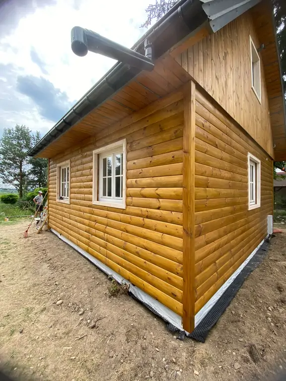 Zbliżenie okna i obramowania po renowacji drewnianej elewacji.