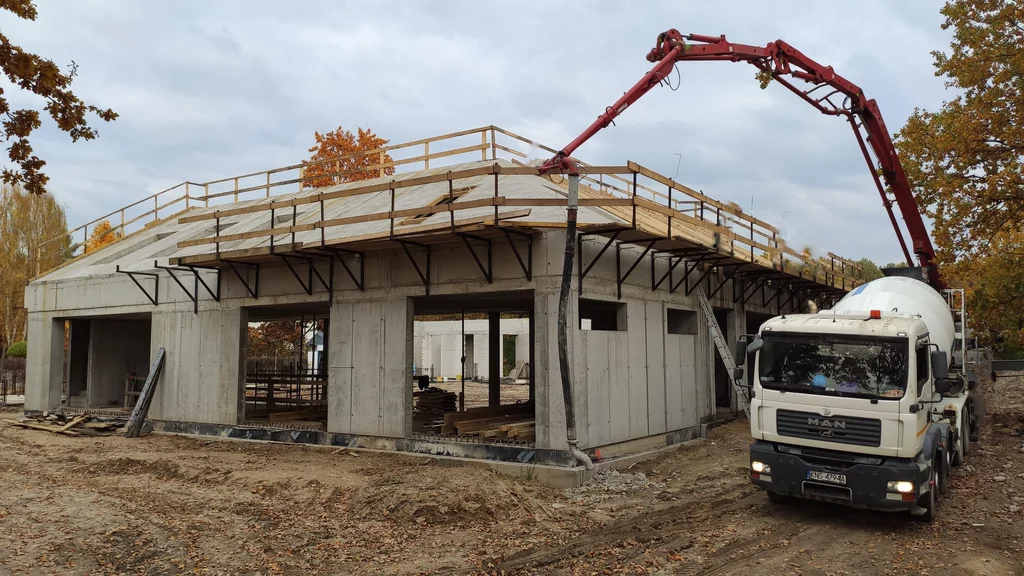Betonowanie skośnego stropu żelbetowego pompą – budynek z betonu architektonicznego w stanie surowym