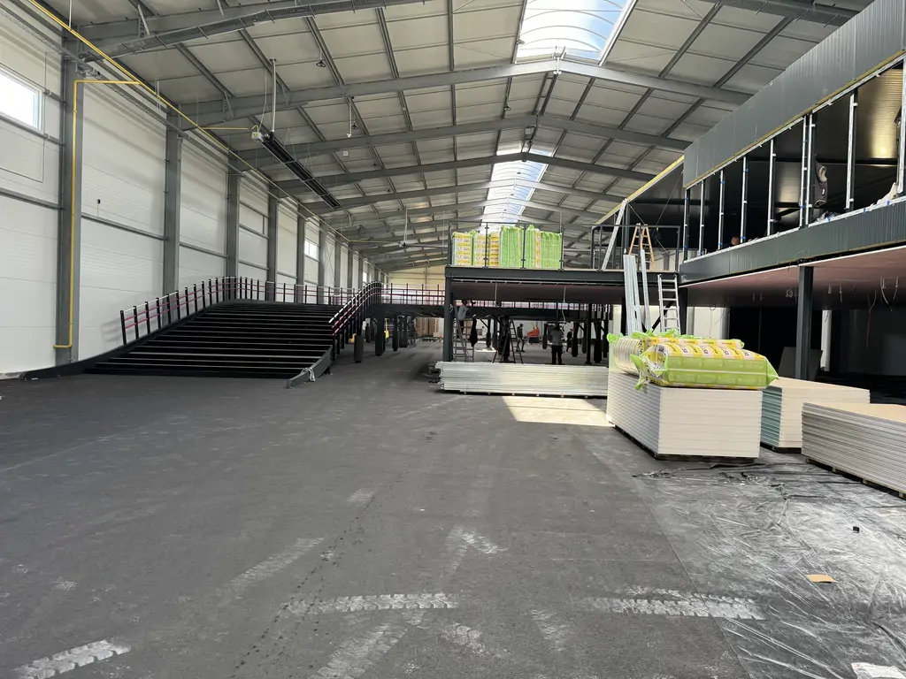 Hala gokartowa w trakcie realizacji, z antresolą, rampą oraz przygotowaną nawierzchnią toru.