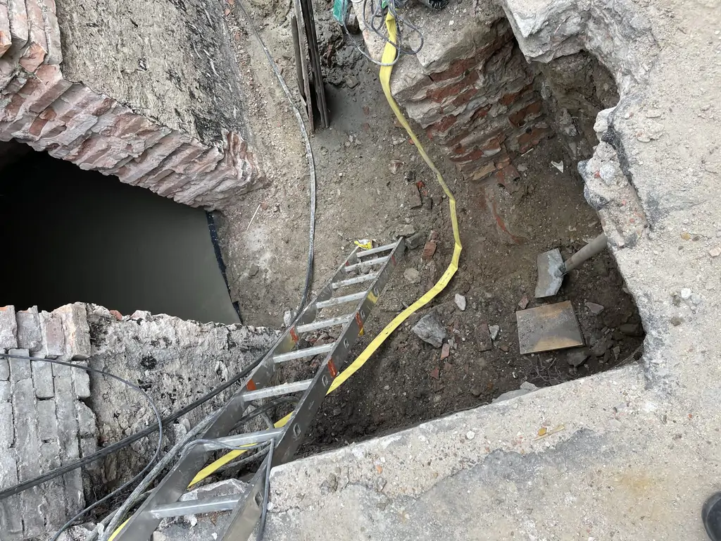 Prace ziemne i odkrycie konstrukcji przyziemia w trakcie kompleksowej przebudowy budynku.