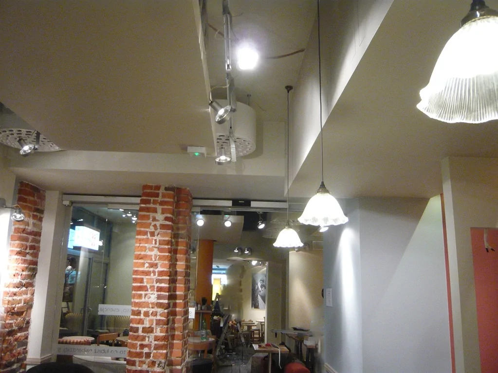 Sufit i oświetlenie w sali Green Caffè Nero, ceglane filary i główne przejście