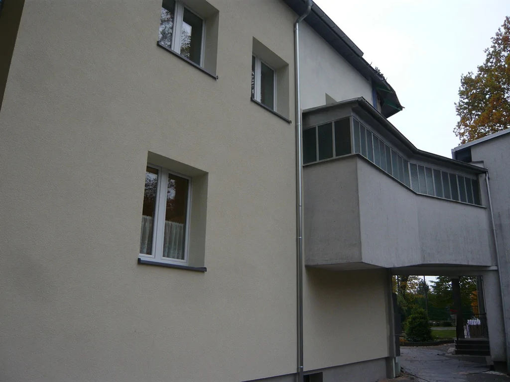 Połączenie brył budynku po remoncie; elewacja i zadaszony łącznik