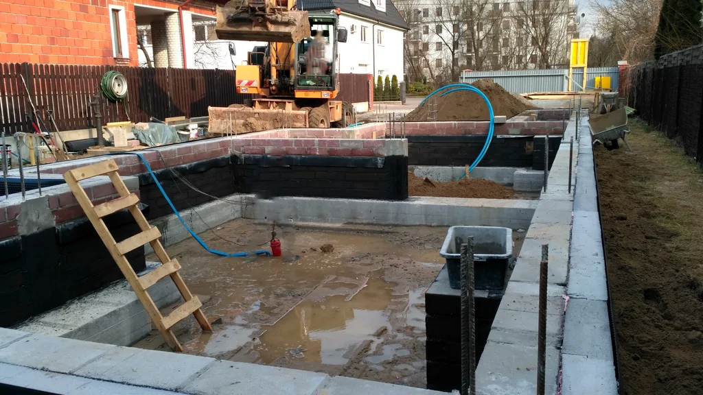 Fundamenty pod dom jednorodzinny, widok na wykonane ławy i wymurowane ścianki fundamentowe