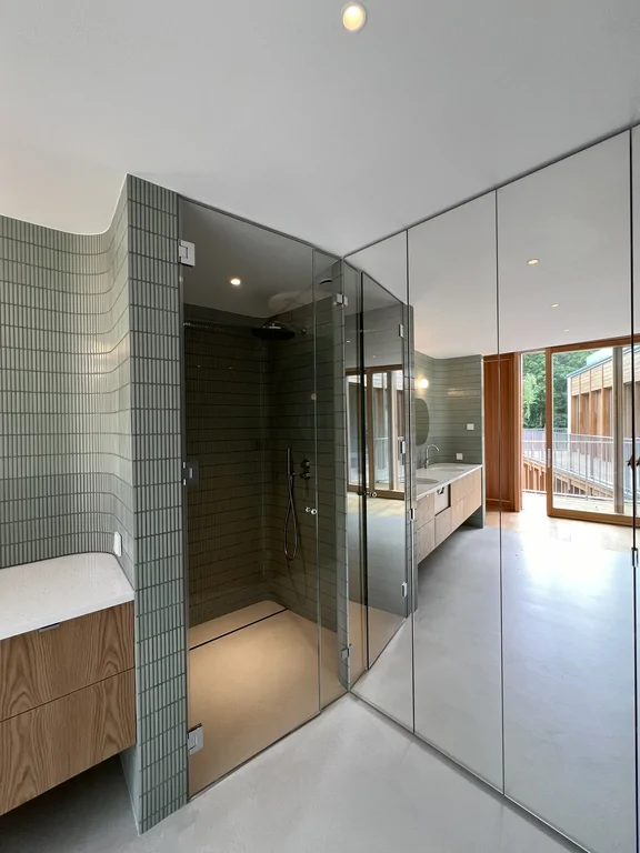 Umywalka z podwójną baterią przy zielonej ścianie i wyjściu na balkon