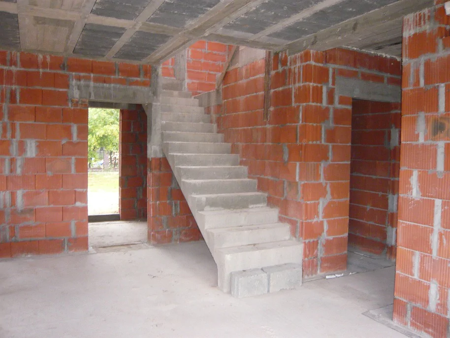 Wnętrze w stanie surowym: żelbetowe schody i ściany z pustaków ceramicznych