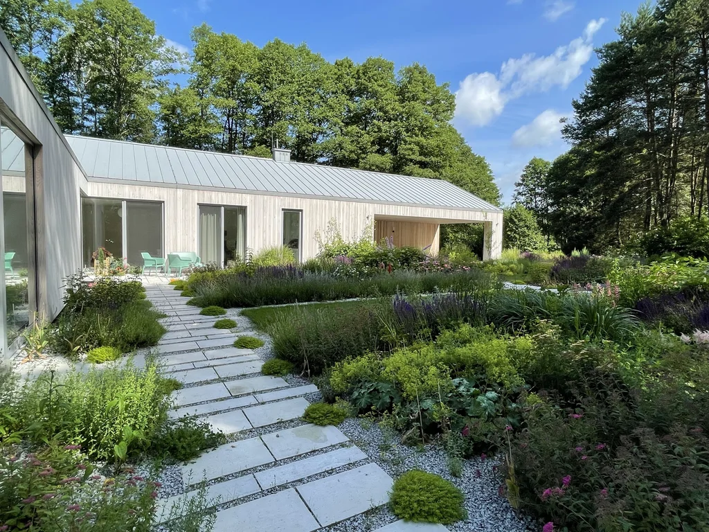 Strefa ogrodu i dojścia – ścieżka z płyt wśród nasadzeń, elewacja z pionowego deskowania