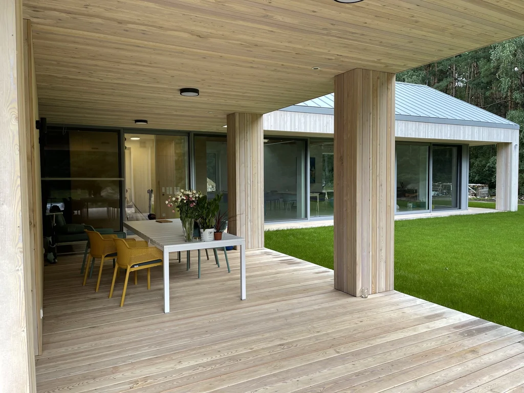 Zadaszona strefa wypoczynkowa na tarasie z drewnianą konstrukcją