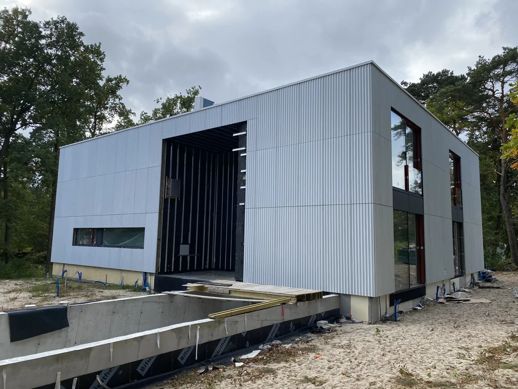 Widok na elewację, duża strefa wejściowa, rampa zjazdowa do garażu 