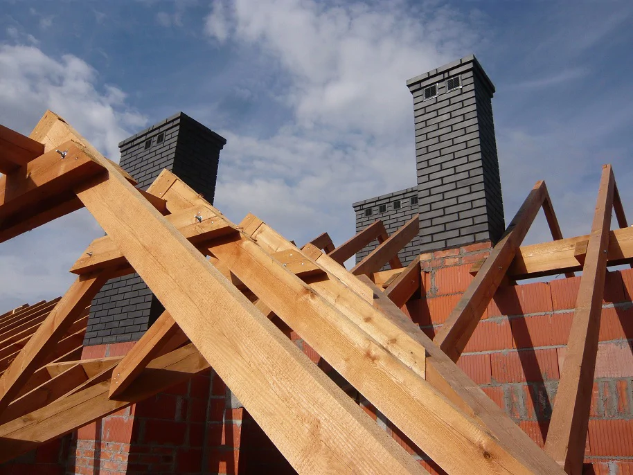Kominy i elementy więźby dachowej – zbliżenie na konstrukcję drewnianą i murowane kominy