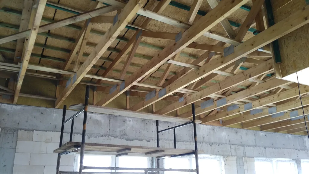 widok na wiązary dachowe, ściany z pustaka ceramicznego i elementy żelbetowe 