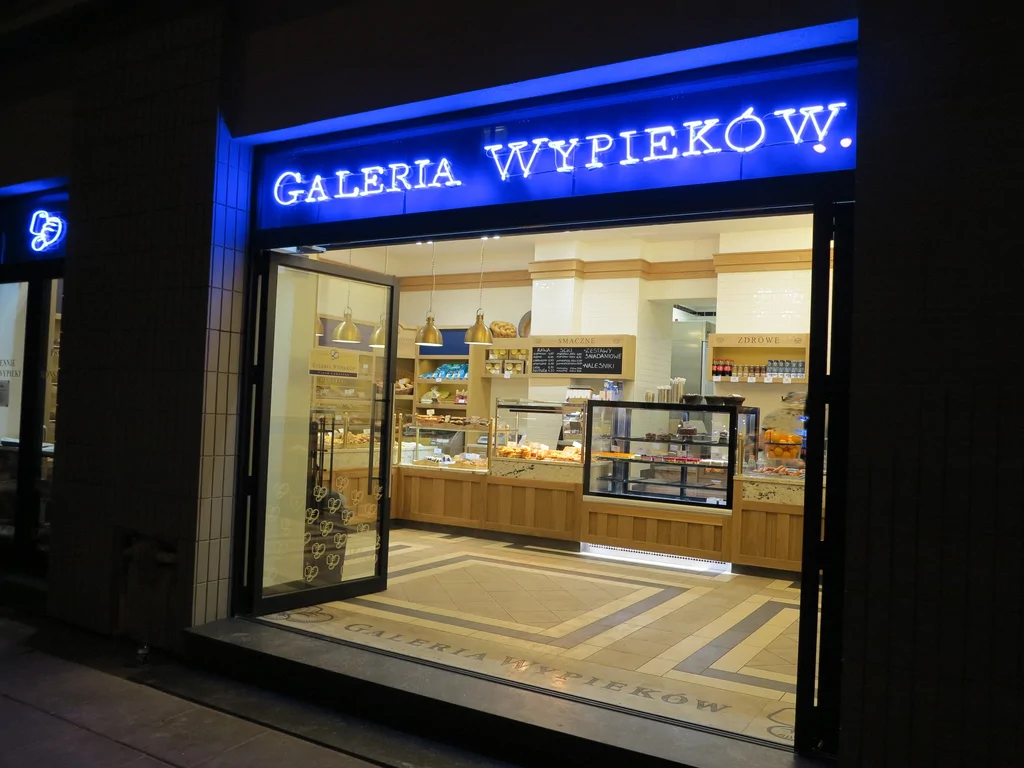 Zdjęcia z zewnątrz, podświetlane logo piekarni, stolarka okienna ciemna, wykonana elewacja 