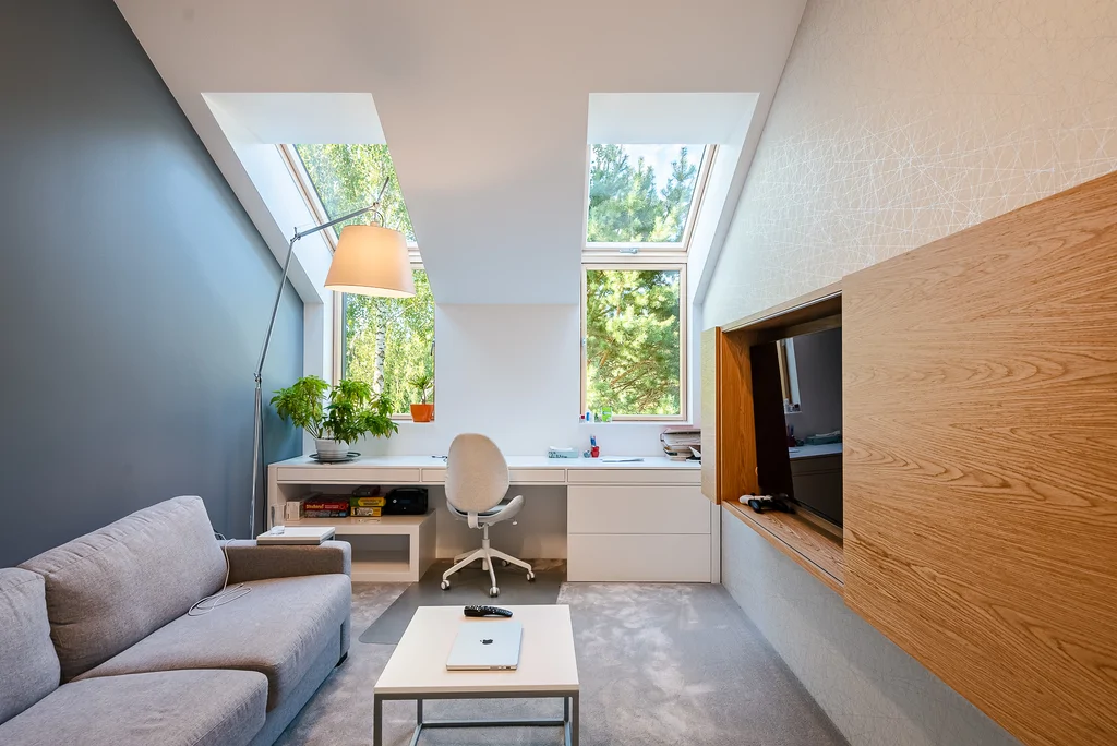 Pokój gościnny, wykładzina na podłodze, kanapa, TV, biurko z krzesłem