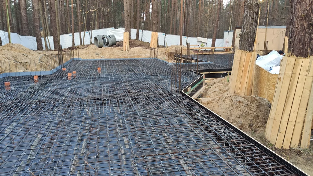 Przygotowanie płyty fundamentowej ze zbrojeniem i przepustami instalacyjnymi na działce leśnej