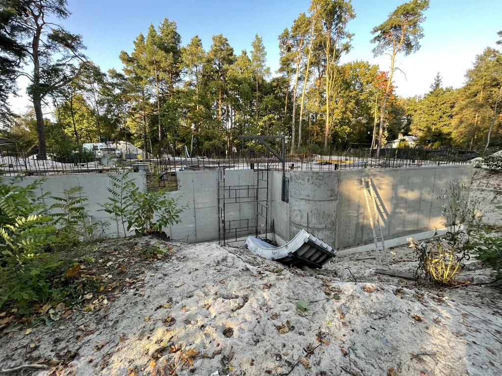 Konstrukcja kondygnacji podziemnej domu w głębokim wykopie na działce leśnej