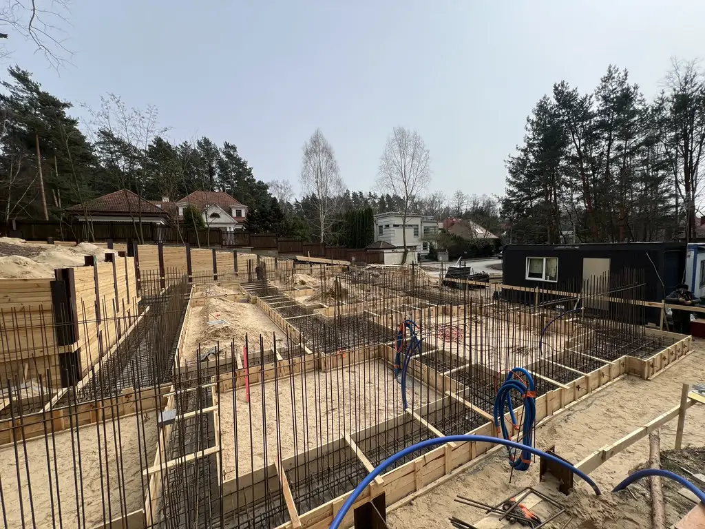 Zbrojenie i deskowanie fundamentów na placu budowy domu jednorodzinnego na działce ze skarpą.