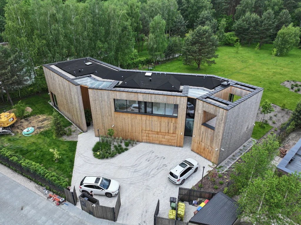 Dom Prawdziwka – widok z drona na dach płaski ze świetlikami oraz układ bryły od strony podjazdu.