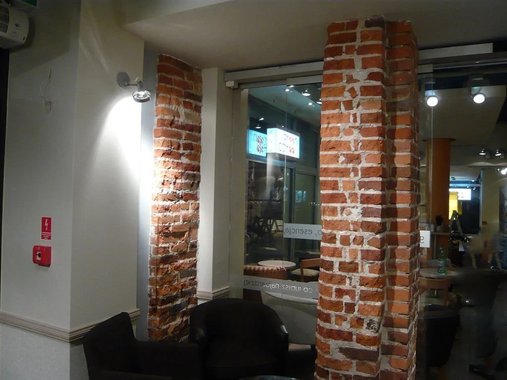 Detal ceglanych filarów i strefy wypoczynku w Green Caffè Nero po remoncie