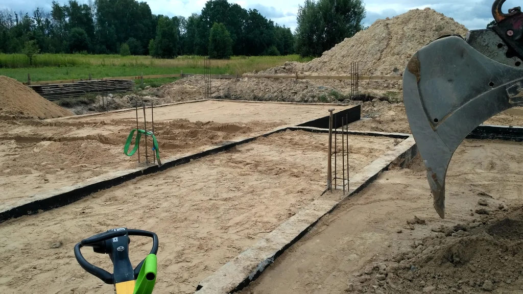 Wykonane fundamenty na budowie, prace zasypowe z zagęszczeniem