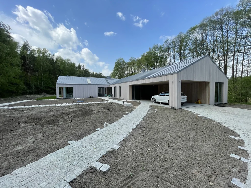 Podjazd i ścieżki z kostki prowadzące do nowoczesnego domu