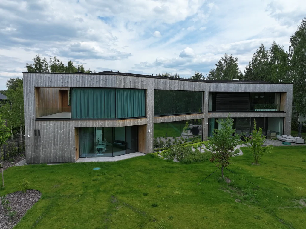 Dom Prawdziwka – szerokie ujęcie od strony ogrodu: drewniana elewacja, przeszklenia i taras.