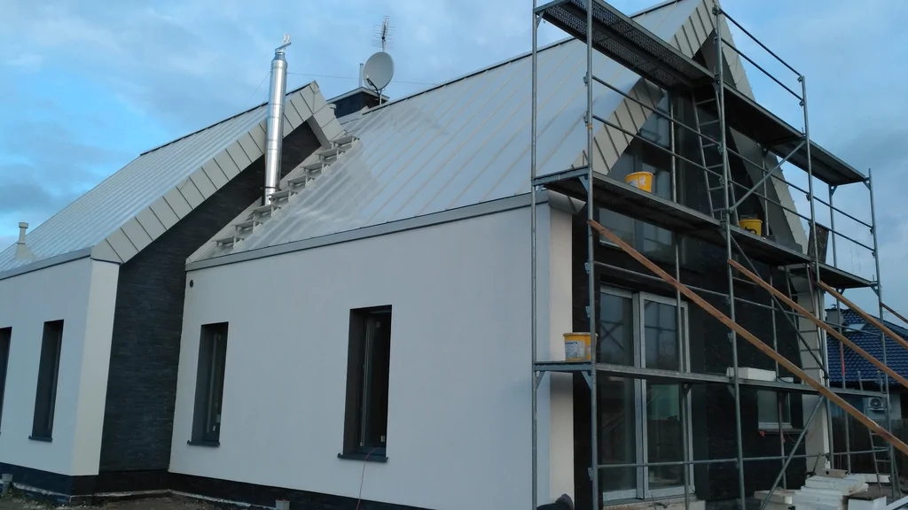 Dom w stanie deweloperskim, rusztowanie przy elewacji 