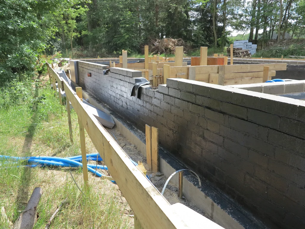 ściany fundamentowe pomalowane szlamem 