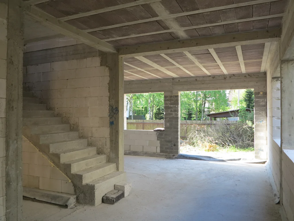 Zdjęcie wewnątrz widok na schody żelbetowe, elementy konstrukcyjne, strop gęstożebrowy oraz mury z silikatów