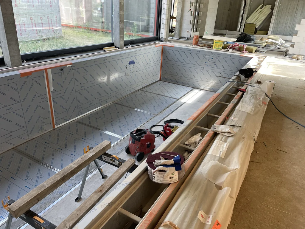 Niecka basenu wewnętrznego podczas montażu i prac wykończeniowych w nowoczesnym domu jednorodzinnym