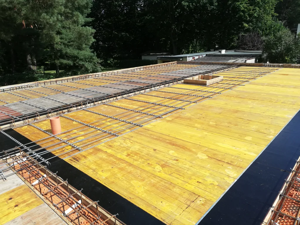 Zbrojenie i deskowanie stropodachu nowoczesnego domu jednorodzinnego w trakcie budowy