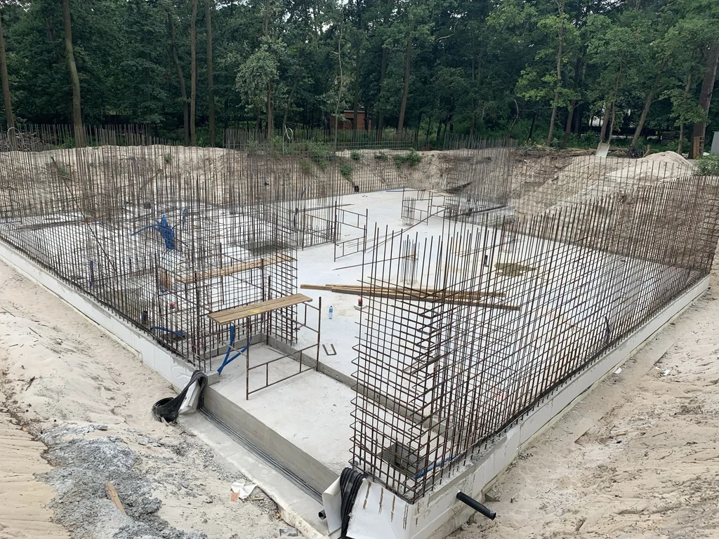 Wykop pod dom z płytą fundamentową i zbrojeniem ścian kondygnacji podziemnej