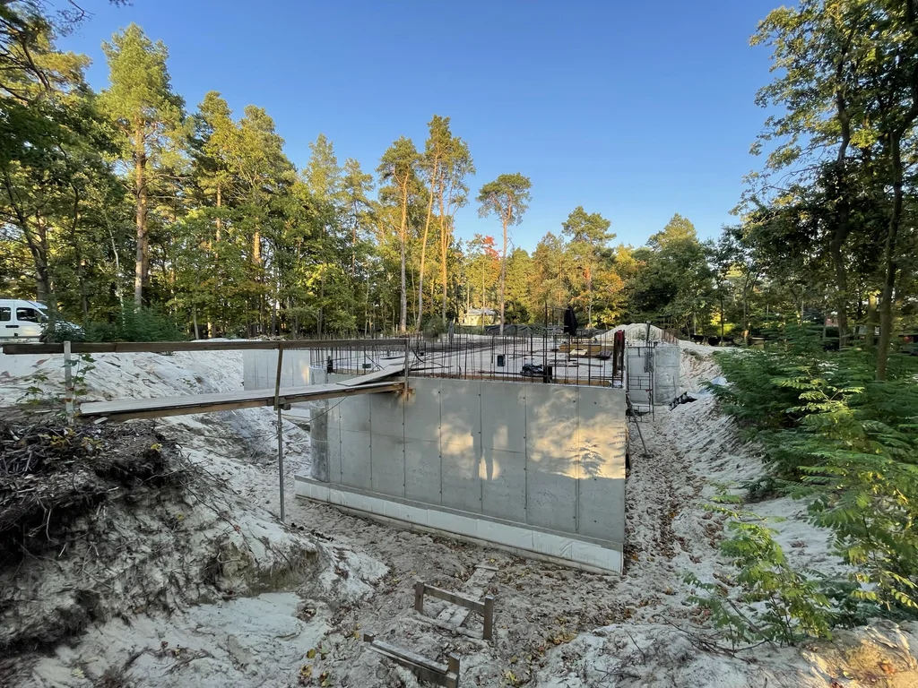 Szeroki widok żelbetowych ścian podziemia i przygotowania zbrojenia stropu nad kondygnacją podziemną