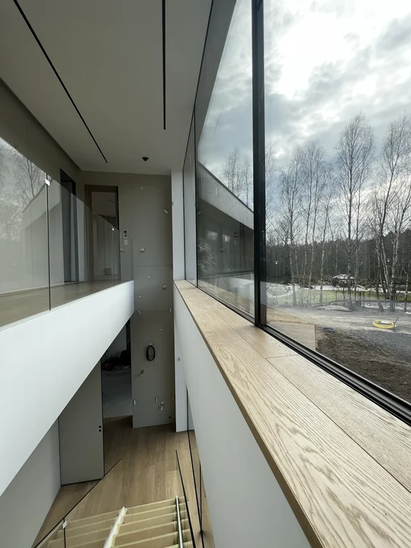 Ujęcie pokazujące funkcję „filtra” między strefami; ciepła podłoga drewniana i dyskretne światło liniowe w suficie.