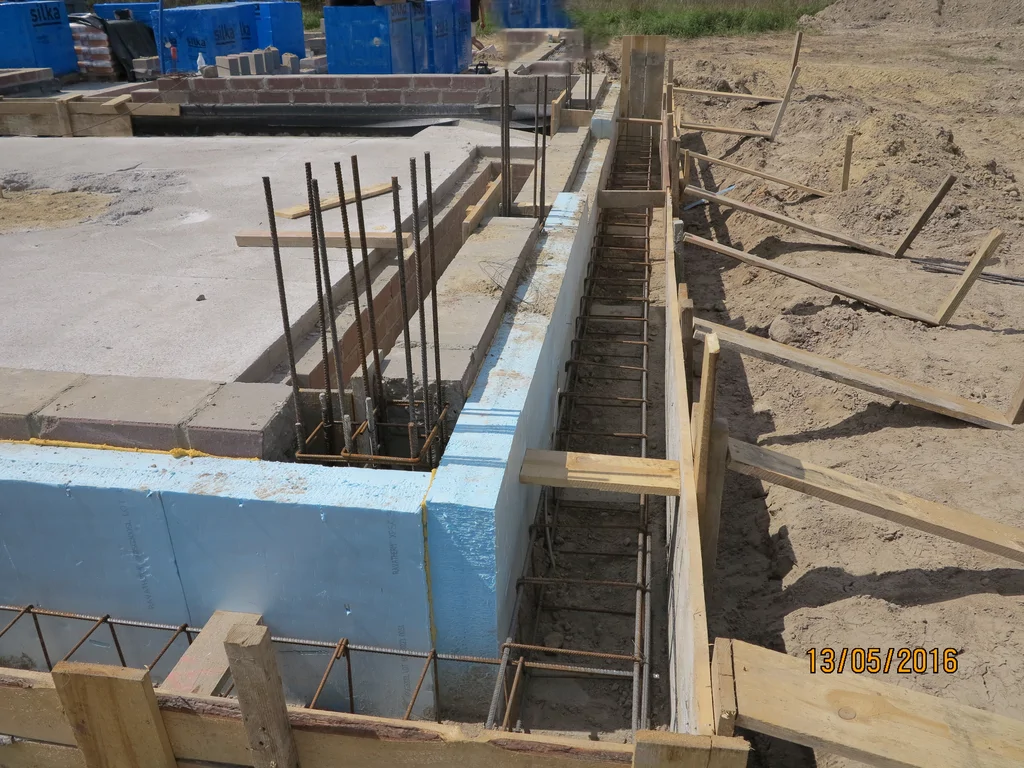 ławy fundamentowe, wykonane ściany fundamentowe z bloczka pokryte szlamem, częściowo wylane słupy 