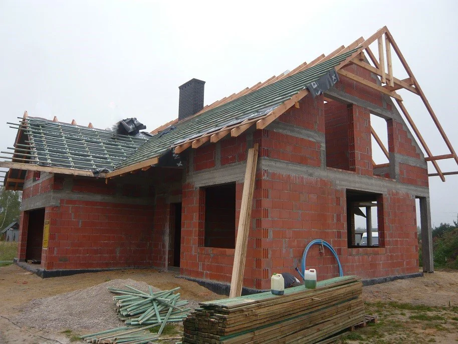 Dom w stanie surowym z membraną i łatami na dachu, przygotowanie pod dachówkę