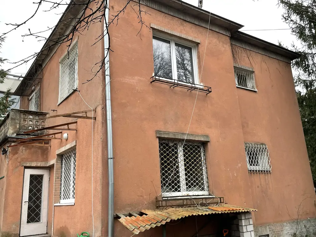 Budynek przed modernizacją – elewacja zewnętrzna z oknami zabezpieczonymi kratami.