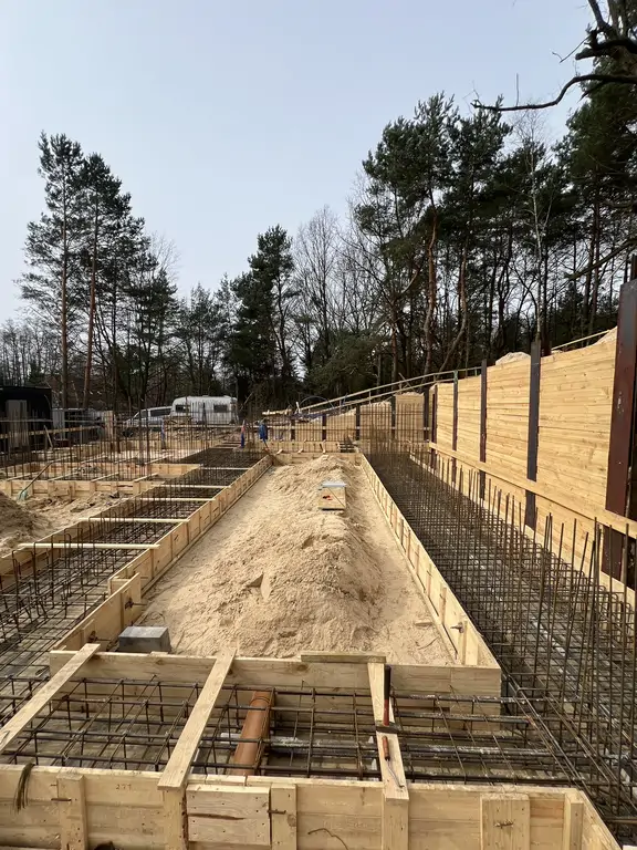 Deskowanie ław fundamentowych i zbrojenie wzdłuż skarpy na etapie prac fundamentowych.