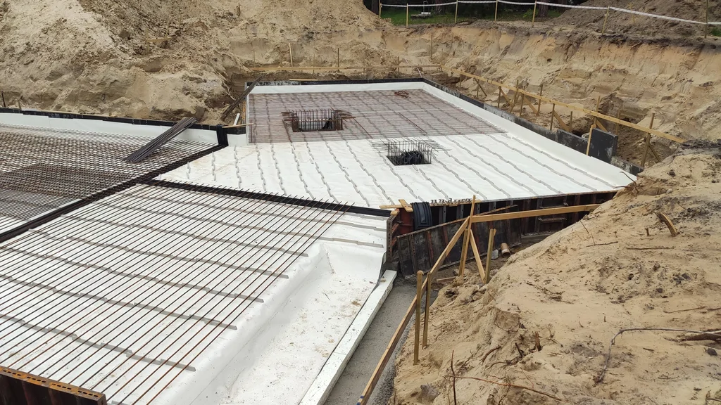 Zbrojenie płyty fundamentowej domu jednorodzinnego ze szczelną piwnicą w trakcie budowy
