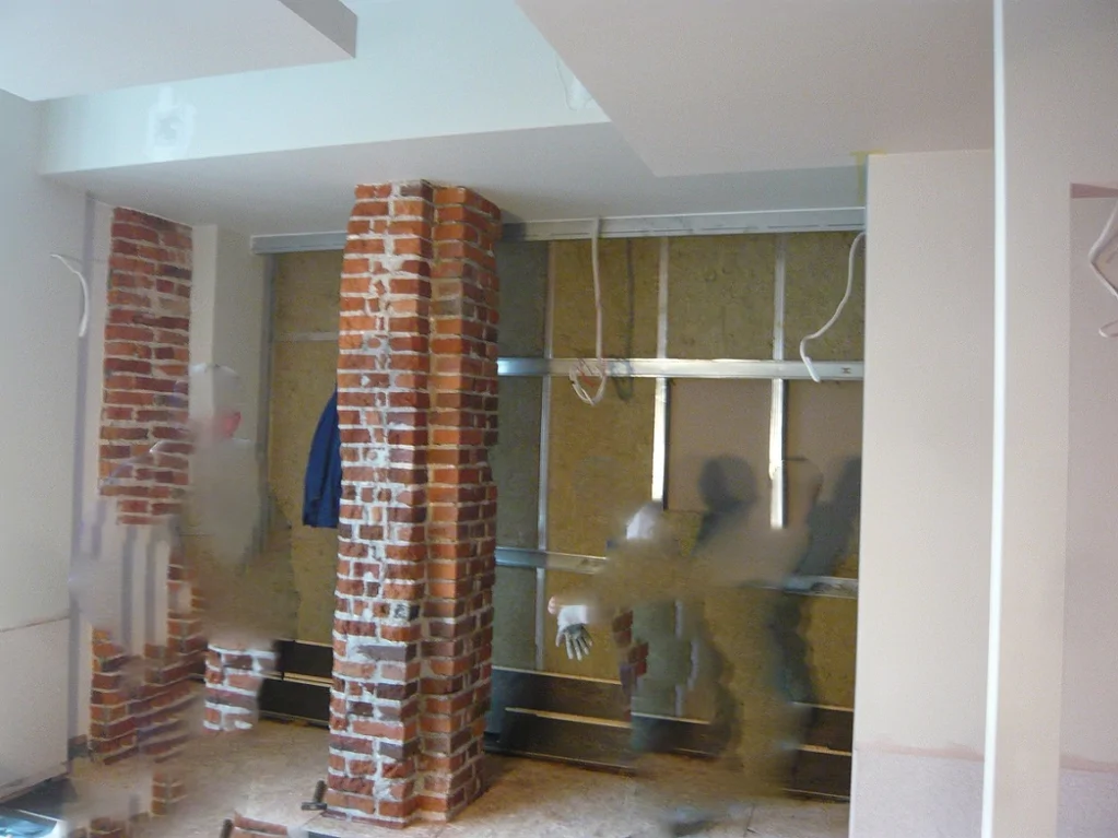 Montaż ścian i instalacji we wnętrzu Green Caffè Nero, ceglane filary i konstrukcja zabudowy