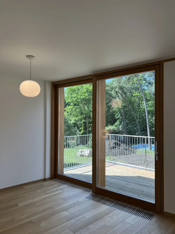 Jasny pokój z drewnianą podłogą, białą zabudową i oświetleniem ściennym