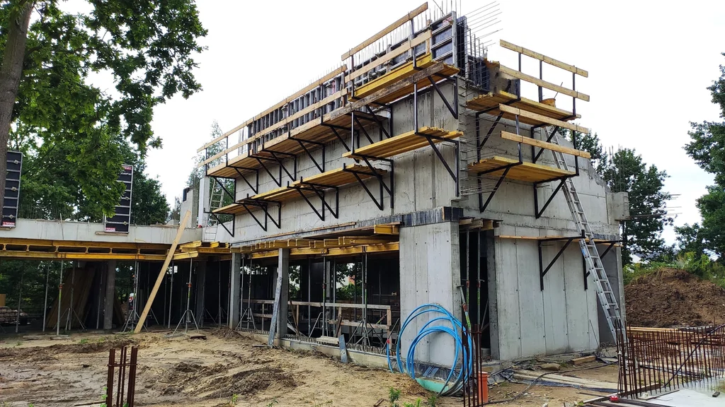 Ściany z betonu architektonicznego i deskowania na piętrze – przygotowanie pod skośny strop żelbetowy