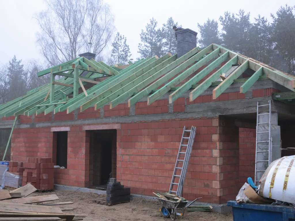 Budowa domu w stanie surowym, cegły Porotherm na ścianach, wykonana więźba dachowa 