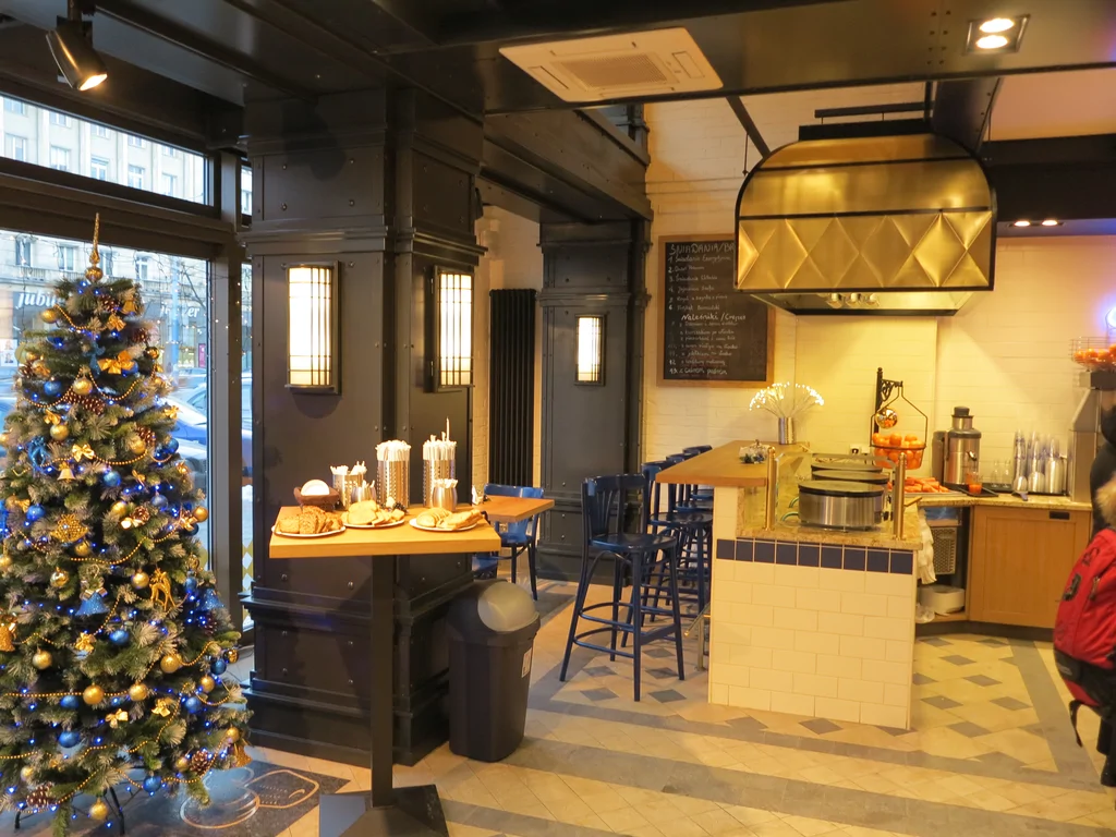 Wnętrza piekarni w stanie deweloperskim, stoliki, witryna okienna, choinka